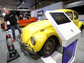 Mike Ingoldsby from Volkswagen vacuums around a 1967 Beetle Bumblebee on display at the Calgary International Auto and Truck Show which ran from April 17-21 at the BMO Centre in Calgary on Monday, April 15, 2019.