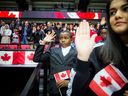 New Canadians take their oath during a special citizenship ceremony held in Ottawa before a hockey game between the Ottawa Senators and the visiting Calgary Flames.  Canada recently announced that it will raise its annual immigration targets.