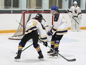 Eric Homersham, à direita, patina durante o aquecimento com seu time de hóquei Calgary Wolverines U15 em 6 de novembro.