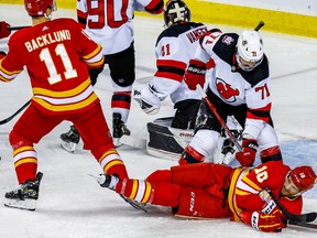 Calgary Flames Jonathan Huberdeau is knocked to the ice by Jonas Siegenthaler of the New Jersey Devils during NHL hockey at the Scotiabank Saddledome in Calgary on Saturday, November 5, 2022. AL CHAREST/POSTMEDIA