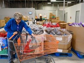 Volunteer Herta Glimpel puts together a hamper at the Calgary Food Bank on Oct. 26. Rising inflation means more Calgarians are turning to the Food Bank.