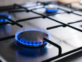 Gas kitchen stove cooking with burning blue flames.  steel panel with gas