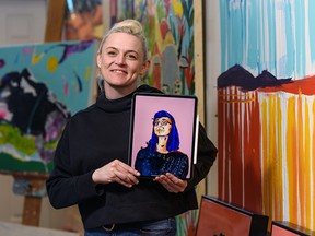 Calgary artist Mandy Stobo holds a portrait of Dr. Deena Hinshaw, painted on March 20, 2020.