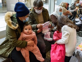 An Afghan family receives winter clothing after arriving at Calgary International Airport on Jan. 11, 2022. The family was among 250 newcomers aided by Calgary Catholic Immigration Society.