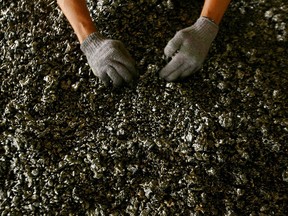 A worker displays nickel ore in a ferronickel smelter in Indonesia.