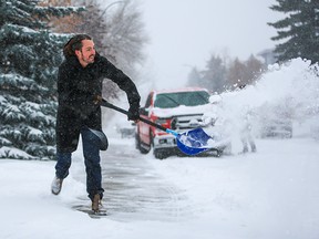 Brayden Hanna clears his sidewalk in West Hillhurst on Wednesday. He might have to do it all over again this weekend, with more snow in the forecast.