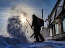 Aaron Stott with Bugaboo Landscaping clears snow along the Edmonton Trail on another frigid day in Calgary on Wednesday, December 21, 2022.  