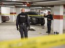 Calgary police officers investigate the scene of an officer-involved shooting in a parkade on Varsity Estates Circle N.W. on Thursday.