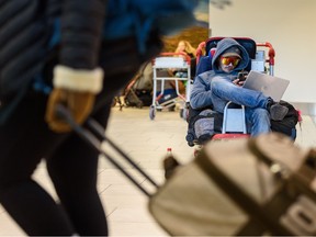 Riley Manahan, whose multiple flights were canceled or delayed, waits to be picked up by friends at Calgary International Airport (YYC) as extreme cold in Calgary and wintry conditions in other parts of Canada caused numerous flight delays and cancellations on Thursday, December .  22, 2022. Manahan hopes to drive to Kelowna as the next available flight to his destination will be after the new year.