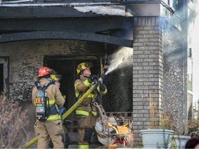 Calgary firefighters deal with hot spots after a fire at a home on Discovery Park SW in Discovery Ridge on Thursday, Oct. 20, 2022. One person was taken to hospital in serious condition following the fire.