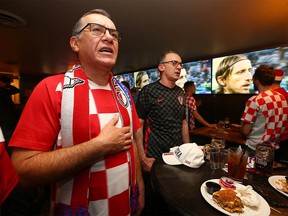 Croatia fans sing the national anthem as they join other fans to watch the World Cup semi-final at Limericks on Macleod Trail SW in Calgary, Tuesday, December 13, 2022.