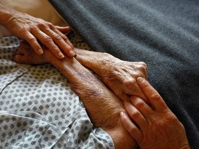 Hospice volunteers caress the hands of a terminally ill patient. Columnist Catherine Ford writes that it's her decision alone to end her own life with medical assistance.
"Nobody has to agree with me, but I think of the heartbreak and pain parents and children of suicide endure. Would MAID not be a better choice?"