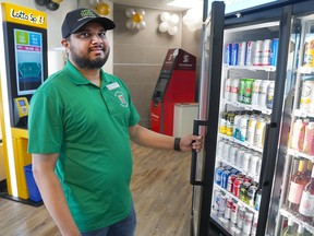 A 7-Eleven employee at a Douglasdale location shows off the new licensed dining area where patrons can now pair their meal with beer or wine.