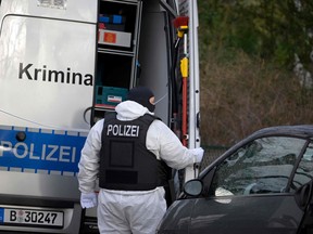 A policeman stands behind a car of the forensic experts during a raid on December 7, 2022 in Berlin that is part of nationwide early morning raids against members of a far-right "terror group" suspected of planning an attack.