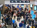 Hundreds of WestJet passengers line up as they wait to rebook canceled flights at Calgary International Airport on Tuesday, December 20, 2022. Weather issues across Canada have caused flight delays and cancellations.
