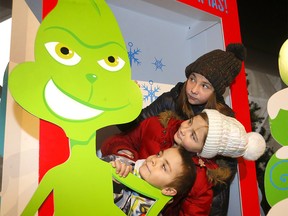 Levi, 8, Jonyia, 10, and Titi Forbes, 11, check out a photo booth as the Calgary Firefighters Toy Association held their annual 2022 event at the Telus Convention Center in Calgary on Sunday, Dec. 18, 2022.