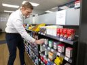 Manager David Loewen restocks shelves with cold medicine at the Pharmedic Pharmacy on Macleod Trail on Thursday.