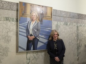 NDP Leader Rachel Notley poses with her official portrait on the third floor of the legislature building in Edmonton on Thursday.