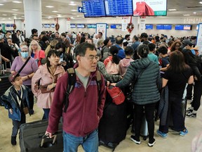 Passengers from Sunwing airlines line up for check-in at Cancun International Airport after many flights to Canada have been canceled because of severe winter weather conditions in various parts of the country, December 27, 2022.