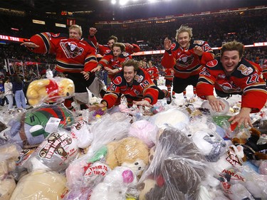 Calgary Hitmen players jump into a pile of stuffed animals after London Hoilett scored on Moose Jaw Warriors goalie Jackson Unger to unleash the teddy bears during the Calgary Hitmen’s 27th annual ENMAX Teddy Bear Toss at the Scotiabank Saddledome in Calgary on Sunday, December 4, 2022.