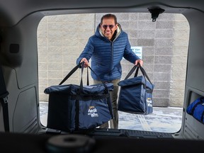 Mohamed Teja, director of Calgary Meals on Wheels, loads meals into a delivery van.  We can all help agencies like Meals on Wheel feed vulnerable Calgarians by donating through the Christmas Fund.