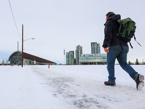 A pedestrian crosses an undeveloped section of land near where Ernest Manning High School once stood on Thursday, December 8, 2022. Calgary city council is currently looking at a local area plan for the Westbrook communities.