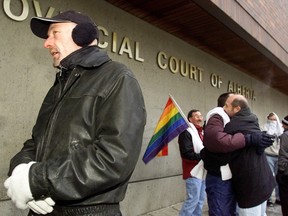 Pride Calgary co-chair Keith Purdy, left, and other members of Calgary's gay community gather outside the Provincial Courthouse Jan. 24, 2003 to support the men charged in the Dec. 12 raid of Goliath's Sauna and Texas Lounge.