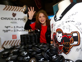 Sutton Garner prepares to sell pox for the I Can for Kids charity during a Calgary Hitmen game.  Darren Makovichuk/Postmedia
