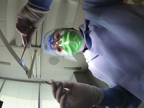 A dentist holds instruments in Skokie, Ill., June 12, 2020. Parents can apply with the Canada Revenue Agency starting today to receive the children's dental benefit that the federal Liberals say is intended to provide cost-of-living relief to low-income Canadians but that critics say is a drop in the bucket.