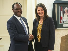 Kaycee Madu shakes hands with Alberta Premier Danielle Smith, in Edmonton, Monday, Oct. 24, 2022. Madu, Alberta's deputy premier, says the proposed sovereignty bill does not grant cabinet unilateral power to rewrite laws behind closed doors, but amendments may be needed to clear that up.