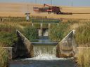 A view of irrigation spillways and a combine unloading grain north of Gleichen, on Sept. 6, 2022. 