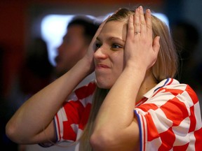 Croatia fan Madison Turbach reacts after Argentina take a 2-1 lead during the World Cup semi-final as she and dozens of other fans pack Limericks on Macleod Tr SW in Calgary Tuesday, Dec. 13, 2022.