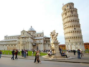 Tourists walk past the Leaning Tower of Pisa, free of scaffolding for the first time after 20 years of stabilization and restoration works April 26, 2011. According to legend, the tower was started in 1173 after a Pisan noblewoman left 60 coins to the city.  her will to build a magnificent belfry.  But after only three levels were built, the tower began to lean and sink into its foundations on one side.  Although panic-stricken architects and engineers have since tried to stabilize it, the tower has continued to tip.