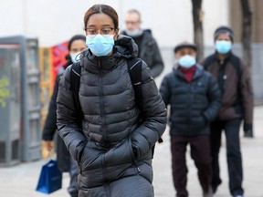 People are shown wearing masks in downtown Calgary on March 1, 2022.