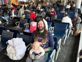 Michael Wortman and his infant daughter in Toronto's Pearson airport on Thursday, December 22 as they wait to get on a standby flight. Wortman and his family are attempting to get to Newfoundland but missed their earlier connection.