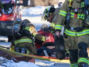 Calgary firefighters console a resident while trying to resuscitate a cat, one of four that died in a house fire in the 5900 block of Dalton Drive N.W. on Wednesday, January 4, 2023. The fire contained to the basement also sent one man to hospital in critical condition.