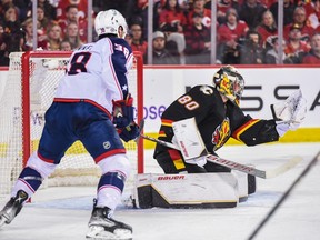 Calgary Flames goaltender Daniel Vladar makes a save against the Columbus Blue Jackets forward Boone Jenner at Scotiabank Saddledome in Calgary on Monday, Jan. 23, 2023.