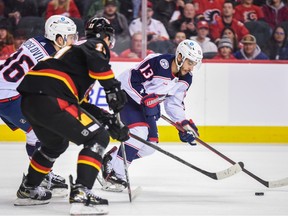 Columbus Blue Jackets forward Johnny Gaudreau against Calgary Flames forward Mikael Backlund  chase the puck at Scotiabank Saddledome in Calgary on Monday, Jan. 23, 2023