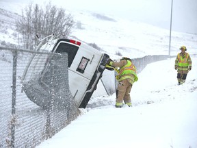 Calgary firefighters secure a van that rolled on Shaganappi Trail north of John Laurie Blvd NW on Friday. There were no injuries in the accident.