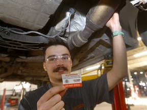 Kal Tire mechanic Curtis Hawley demonstrates as CPS and Kal Tire have launched a program that places vehicle VIN numbers onto catalytic converters to attempt to stop the devices from being stolen.