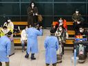 FILE PHOTO: A group of Chinese tourists are led by South Korean soldiers wearing personal protective equipment as they wait for COVID-19 tests upon their arrival at the Incheon International Airport in Incheon, South Korea, January 4, 2023.