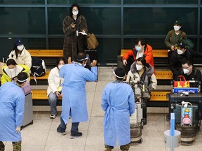 FILE PHOTO: A group of Chinese tourists are led by South Korean soldiers wearing personal protective equipment as they wait for COVID-19 tests upon arrival at Incheon International Airport in Incheon, South Korea, January 4, 2023.