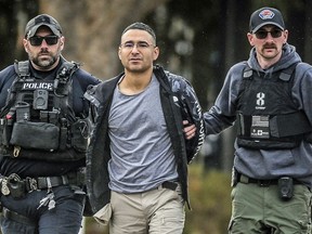 Solomon Pena, center, a Republican candidate for New Mexico House District 14, is taken into custody by Albuquerque Police officers, January 16, 2023, in Albuquerque, N.M.