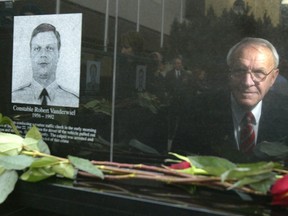 Art Vanderwiel, father of one of the 11 Calgary police officers who died in service, is reflected in the picture of his son Rob Vanderwiel during the official opening to the Police Officers and Firefighters Tribute Plaza at City Hall.