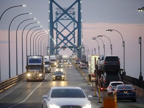 A truck hauling new cars crosses the Ambassador Bridge on the Canada-U.S. border in Windsor, Ontario.