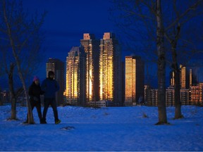East Village condo towers reflect the rising sun behind walkers on Tom Campbell's Hill.