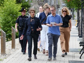 Calgary Police Service Insp. Clare Smart, (far left); Calgary Mayor Jyoti Gondek; Postmedia reporter Jason Herring; and CMLC CEO and president Kate Thompson (far right) walk in the East Village on Thursday, June 9, 2022. 
Gavin Young/Postmedia