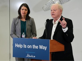 Premier Danielle Smith listens to Dr.  John Cowell, official administrator with AHS answers questions during a press conference on Wednesday, December 21, 2022.