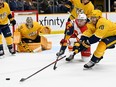 Nashville Predators forward Colton Sissons reaches for the puck as Calgary Flames forward Andrew Mangiapane defends at Bridgestone Arena in Nashville on Monday, Jan. 16, 2023.