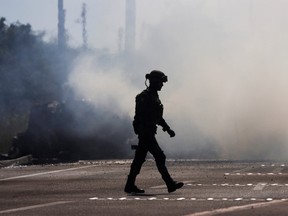 A soldier walks near a burning vehicle set on fire by members of a drug gang as a barricade, following the detention by Mexican authorities of drug gang leader Ovidio Guzman in Culiacan, a son of incarcerated kingpin Joaquin "El Chapo" Guzman, in Mazatlan, Mexico, January 5, 2023.